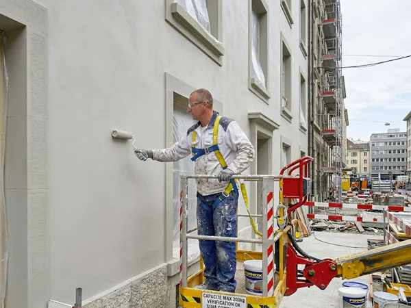 Peintre en bâtiment repeignant un immeuble